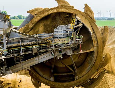 A large machine is in the middle of an open pit.