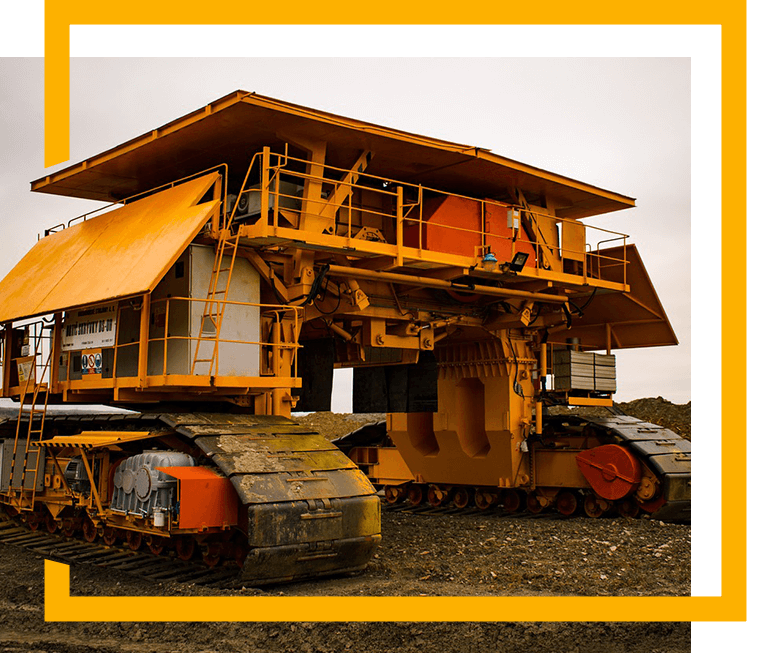 A large yellow dump truck parked on top of a field.